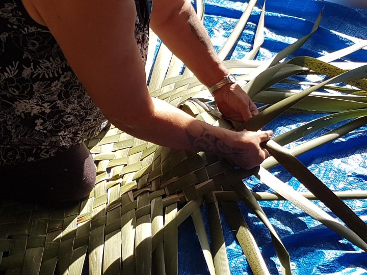 Maata weaving the kete
