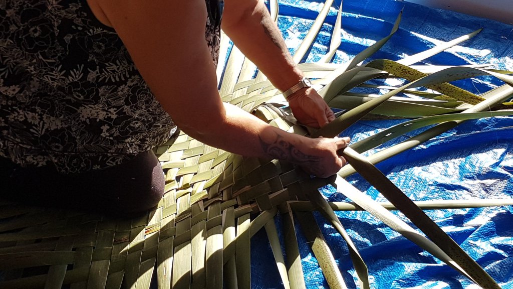 Maata weaving the kete